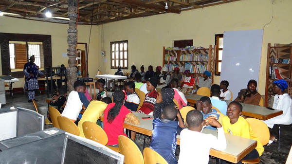 Readers at tables inside the Guneku Royal Community Library.