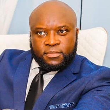 Prof. Dr. Roland Teboh Forbang, head and shoulders, in a dark blue suit and tie.